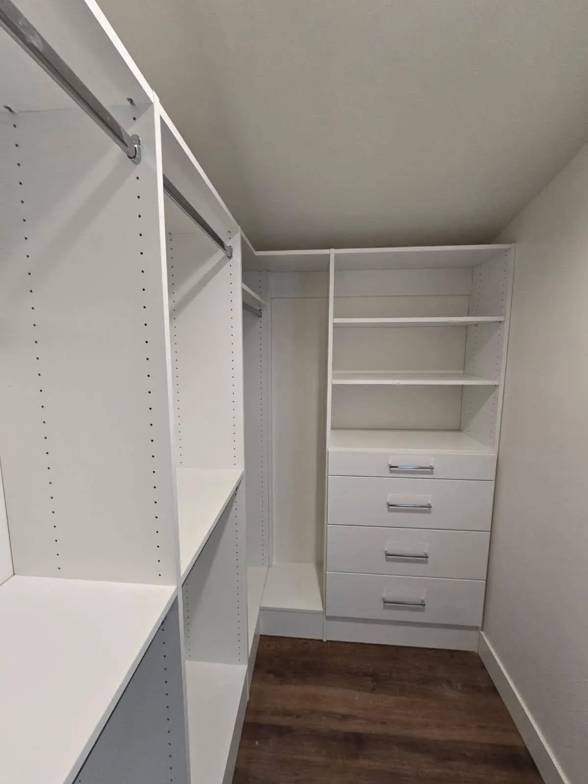 Narrow walk in closet with drawers and double hanging rods